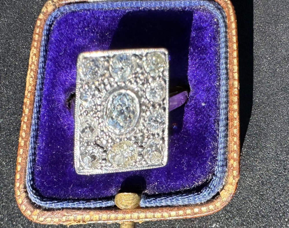 A rectangular platinum and diamond panel ring set with multiple diamonds on an 18ct gold shank. View II