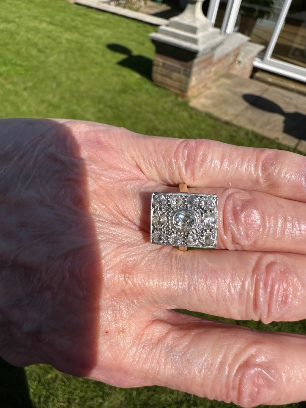A rectangular platinum and diamond panel ring set with multiple diamonds on an 18ct gold shank. View IV