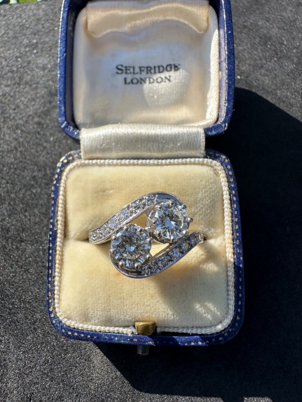 A vintage 14ct white gold double twist ring featuring two central round diamonds encircled by pave-set diamond accents with milgrain detailing. View II