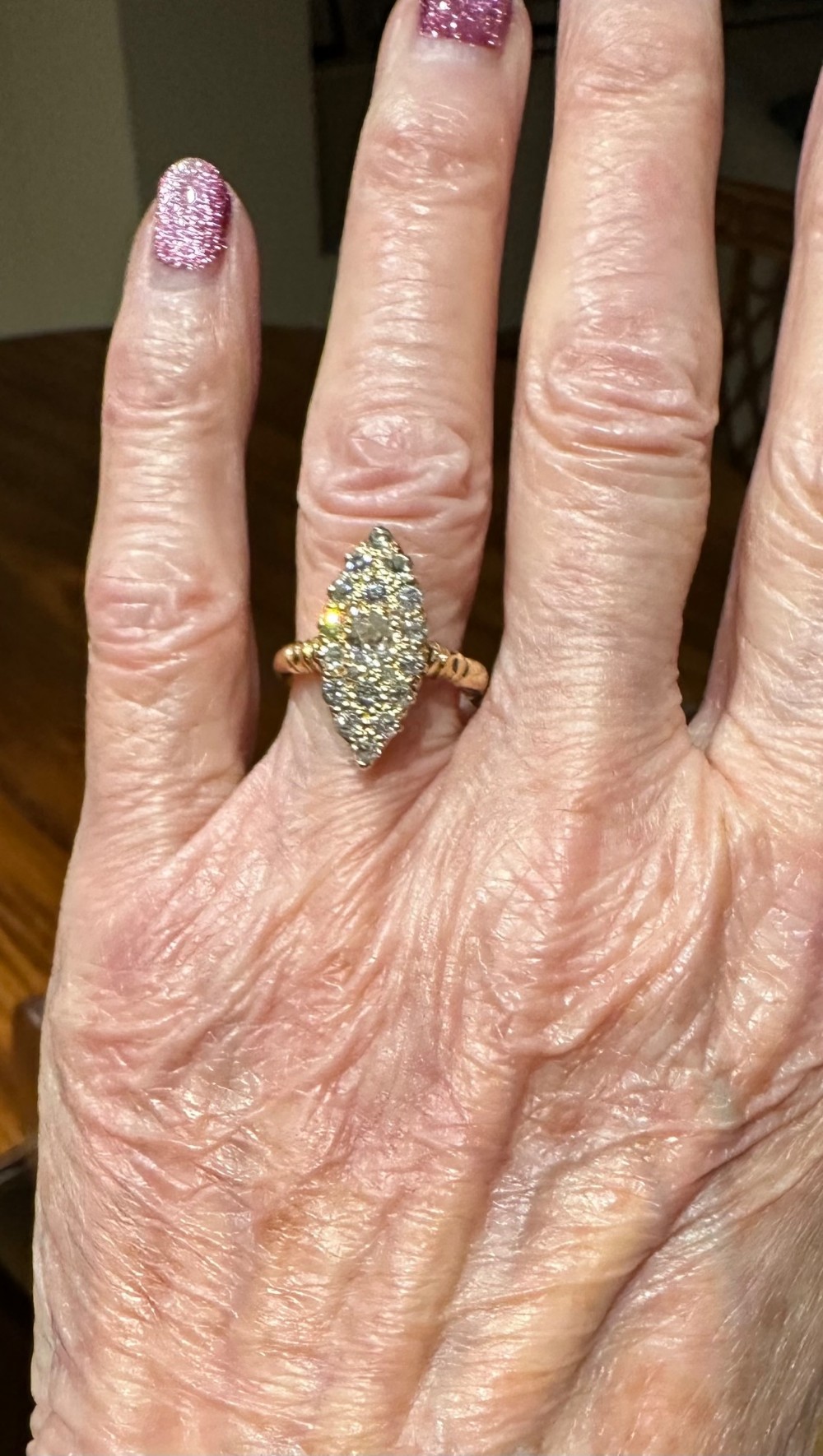 An antique 18ct gold navette-shaped ring set with a cluster of diamond gemstones in an elongated marquise head.