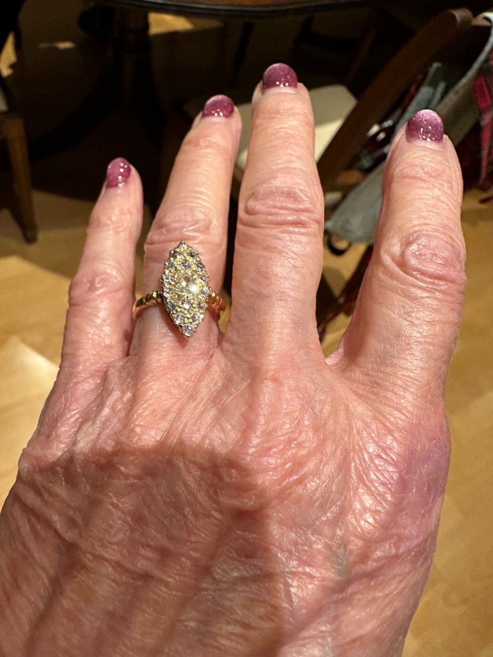 An antique 18ct gold navette-shaped ring set with a cluster of diamond gemstones in an elongated marquise head. View II