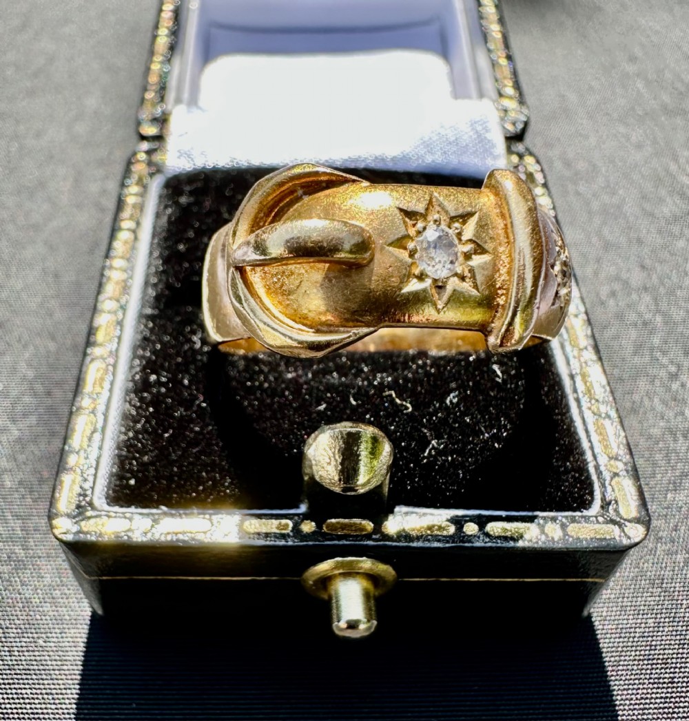 An 18 carat yellow gold band styled as a buckle motif with two star-set diamonds embedded on the surface. View III