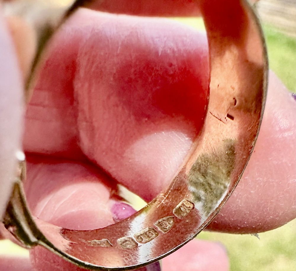 An 18 carat yellow gold band styled as a buckle motif with two star-set diamonds embedded on the surface. View V