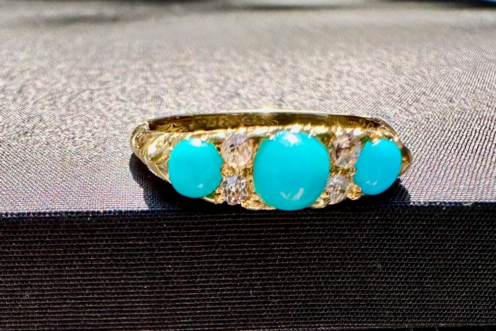 An antique 18ct yellow gold ring set with three turquoise cabochons and four small diamonds. View II