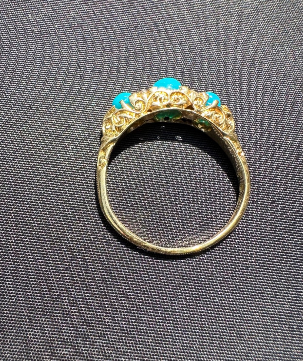An antique 18ct yellow gold ring set with three turquoise cabochons and four small diamonds. View IV