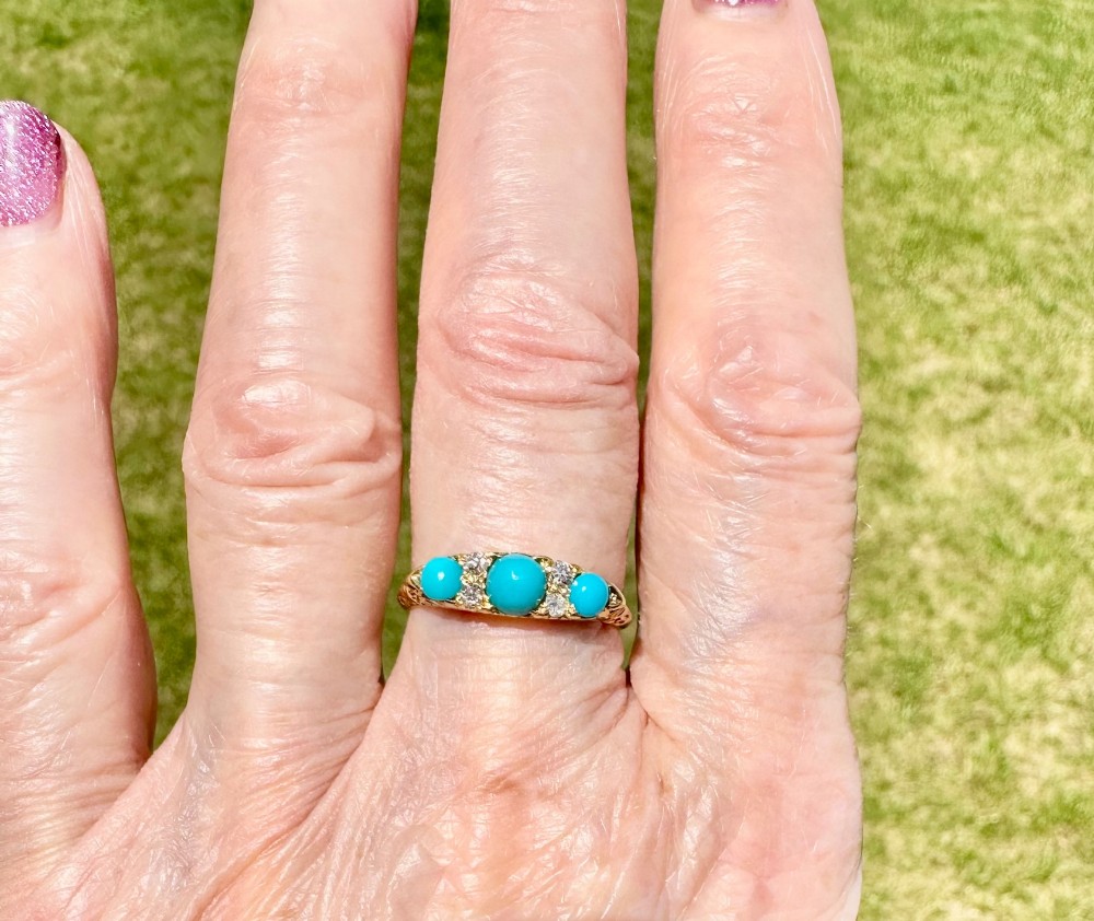 An antique 18ct yellow gold ring set with three turquoise cabochons and four small diamonds. View V