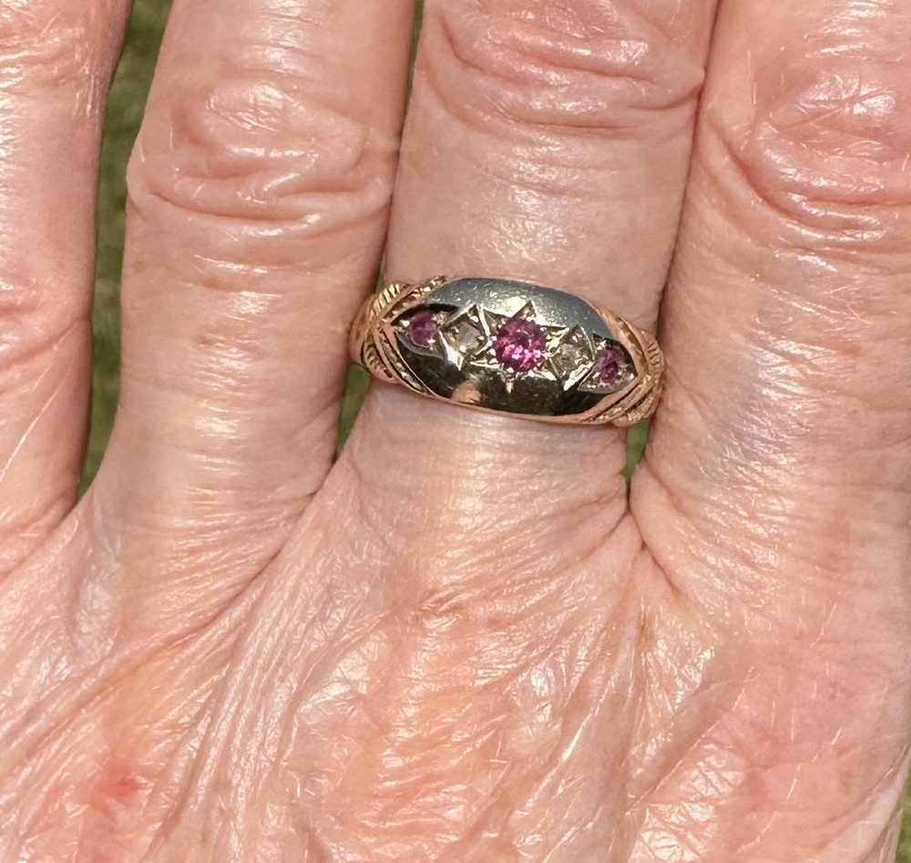 An antique 9ct gold gypsy ring featuring five alternating rubies and diamonds set into star-engraved flush mounts along a carved band.