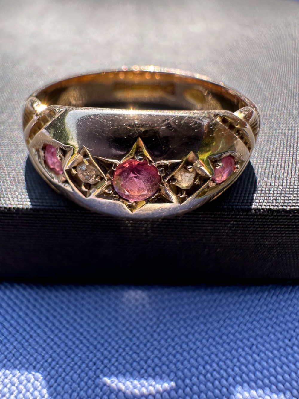 An antique 9ct gold gypsy ring featuring five alternating rubies and diamonds set into star-engraved flush mounts along a carved band. View IV