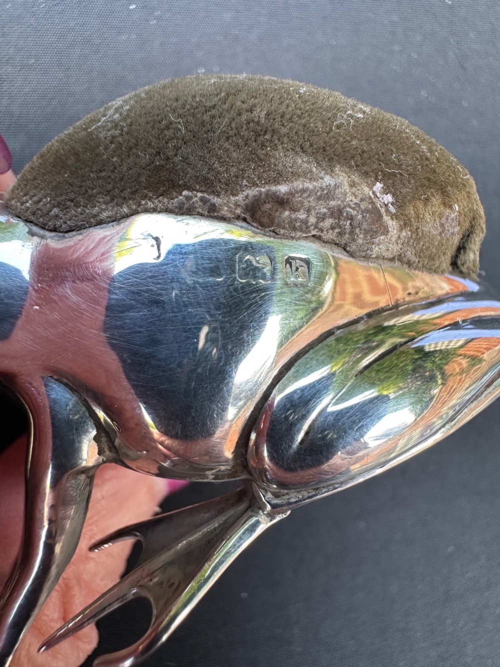 An Edwardian sterling silver pin cushion cast in the shape of a frog with an embedded brown fabric cushion on its back. View IV