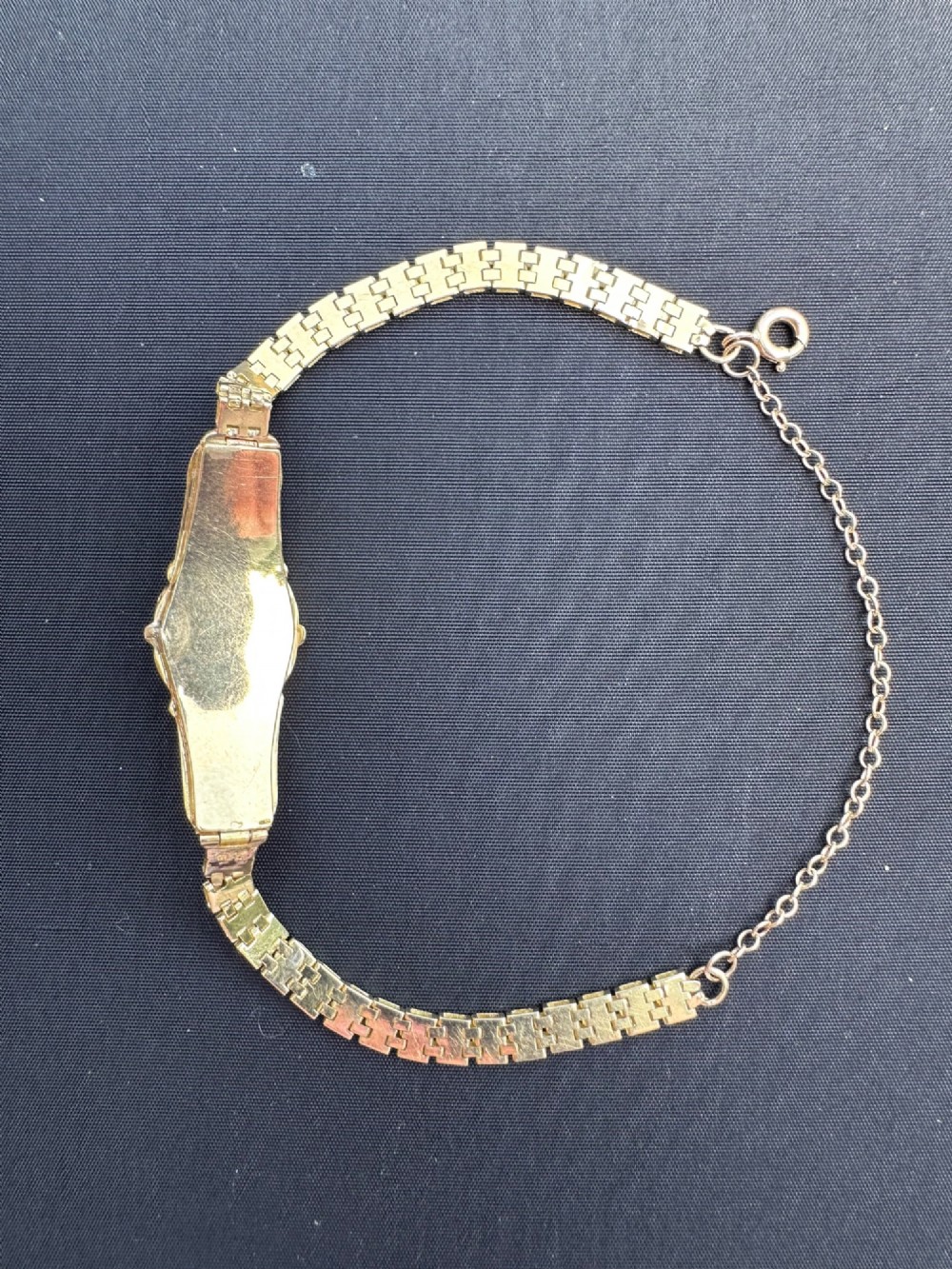 An antique 18ct gold bracelet featuring an ornate central panel set with three turquoise cabochons and seed pearls attached to a flexible gold link strap. View V