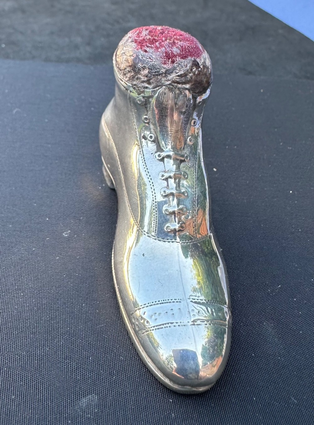 An antique sterling silver pin cushion formed in the shape of a lace-up shoe with a dark red velvet cushion insert. View II