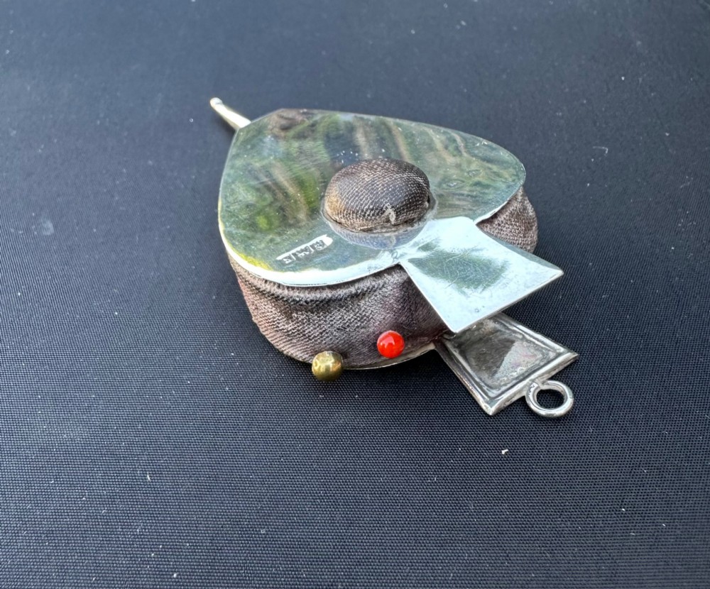 An Edwardian sterling silver pin cushion shaped like fireplace bellows, featuring a central fabric cushion and official British hallmarks. View III