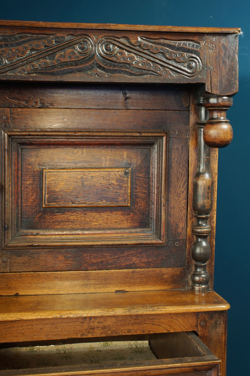 A large 18th-century carved oak court cupboard with recessed upper doors, carved top frieze with initials, and three lower cupboard doors. View XII