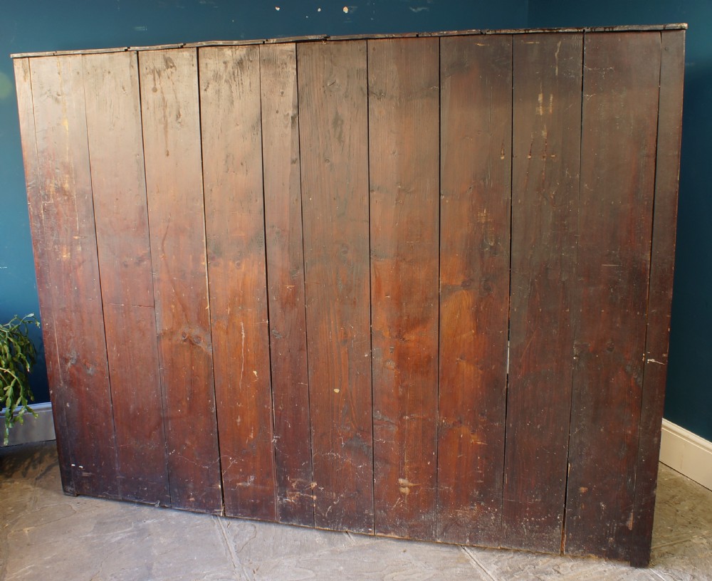 A large 18th-century carved oak court cupboard with recessed upper doors, carved top frieze with initials, and three lower cupboard doors. View XIII