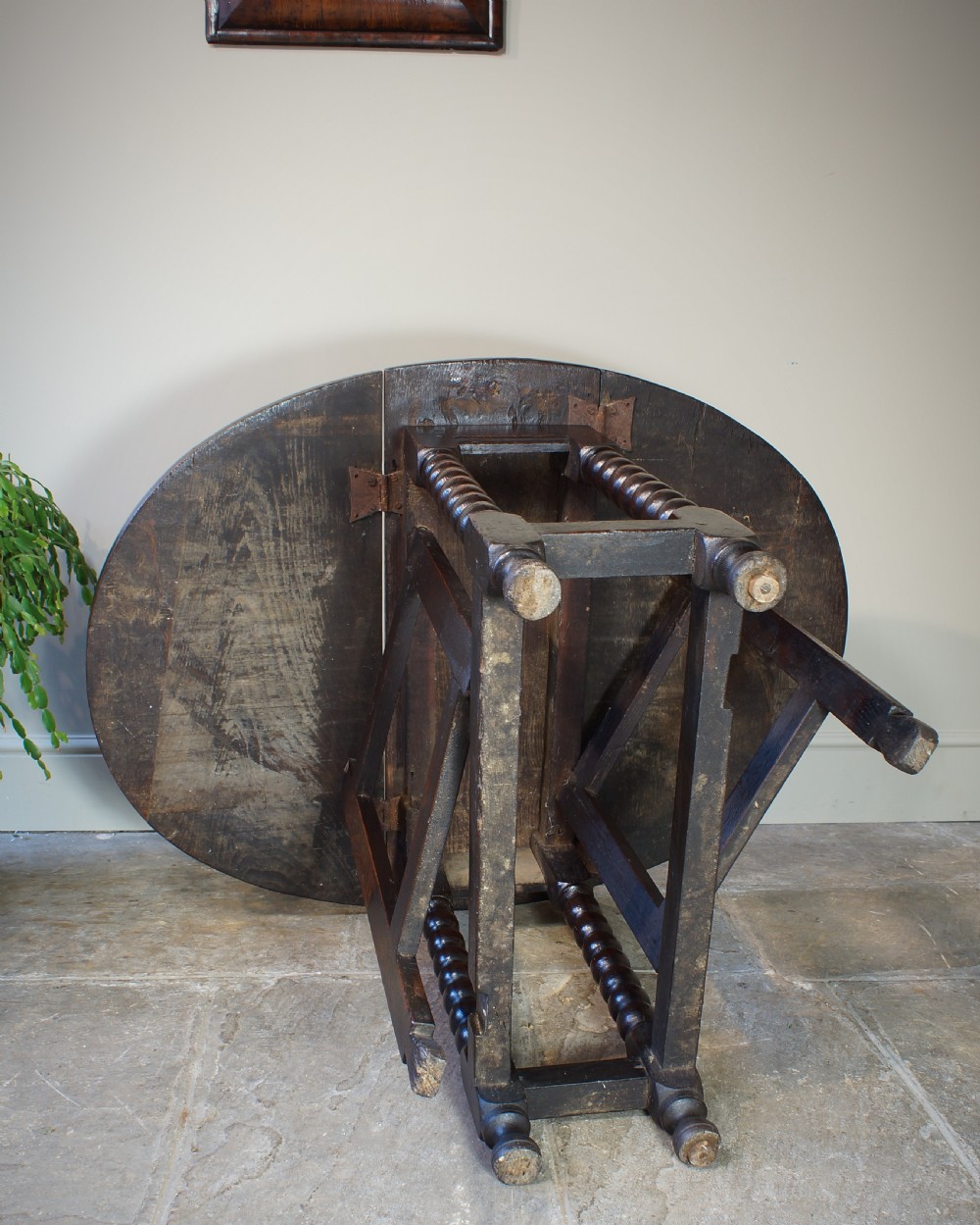 A small 17th-century dark oak gateleg table featuring bobbin-turned legs, drop-leaf top, and lower stretchers. View V