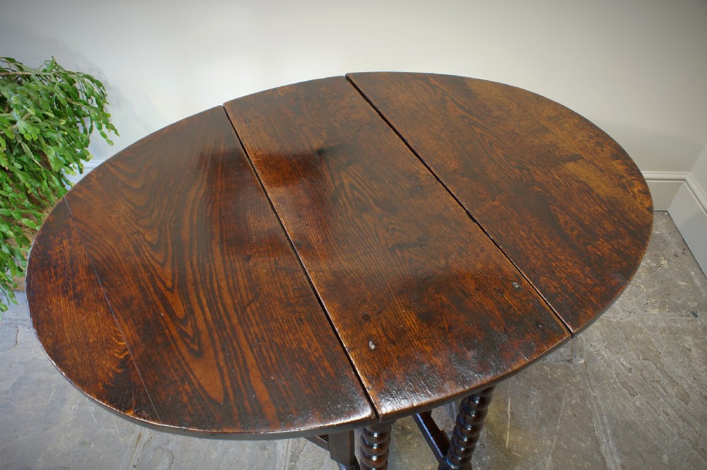 A small 17th-century dark oak gateleg table featuring bobbin-turned legs, drop-leaf top, and lower stretchers. View VI