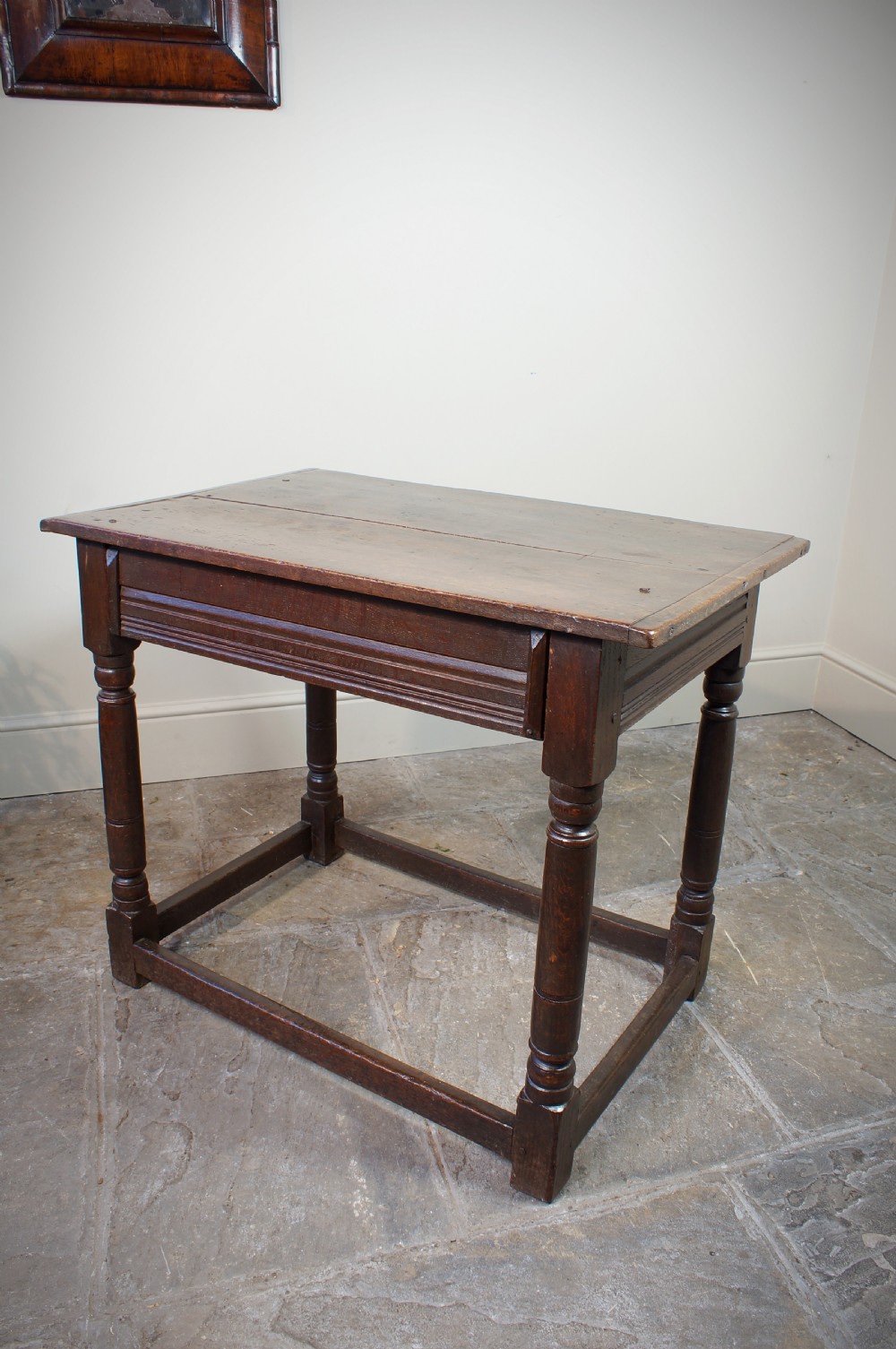 A seventeenth-century dark oak side table featuring a rectangular plank top, moulded apron, turned legs, and perimeter stretchers. View V