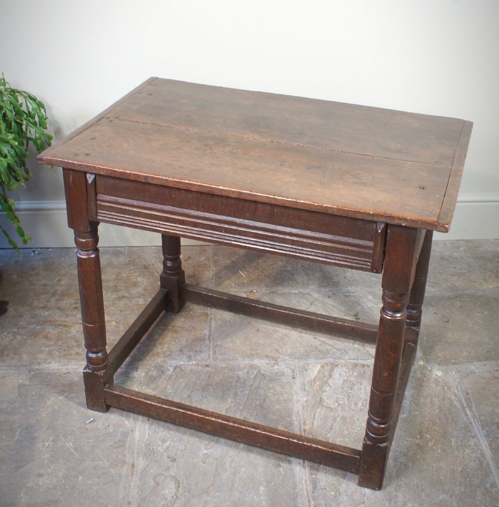 A seventeenth-century dark oak side table featuring a rectangular plank top, moulded apron, turned legs, and perimeter stretchers. View XI