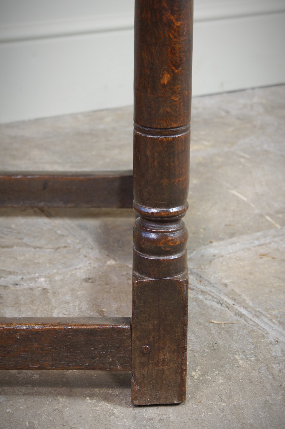 A seventeenth-century dark oak side table featuring a rectangular plank top, moulded apron, turned legs, and perimeter stretchers. View IX