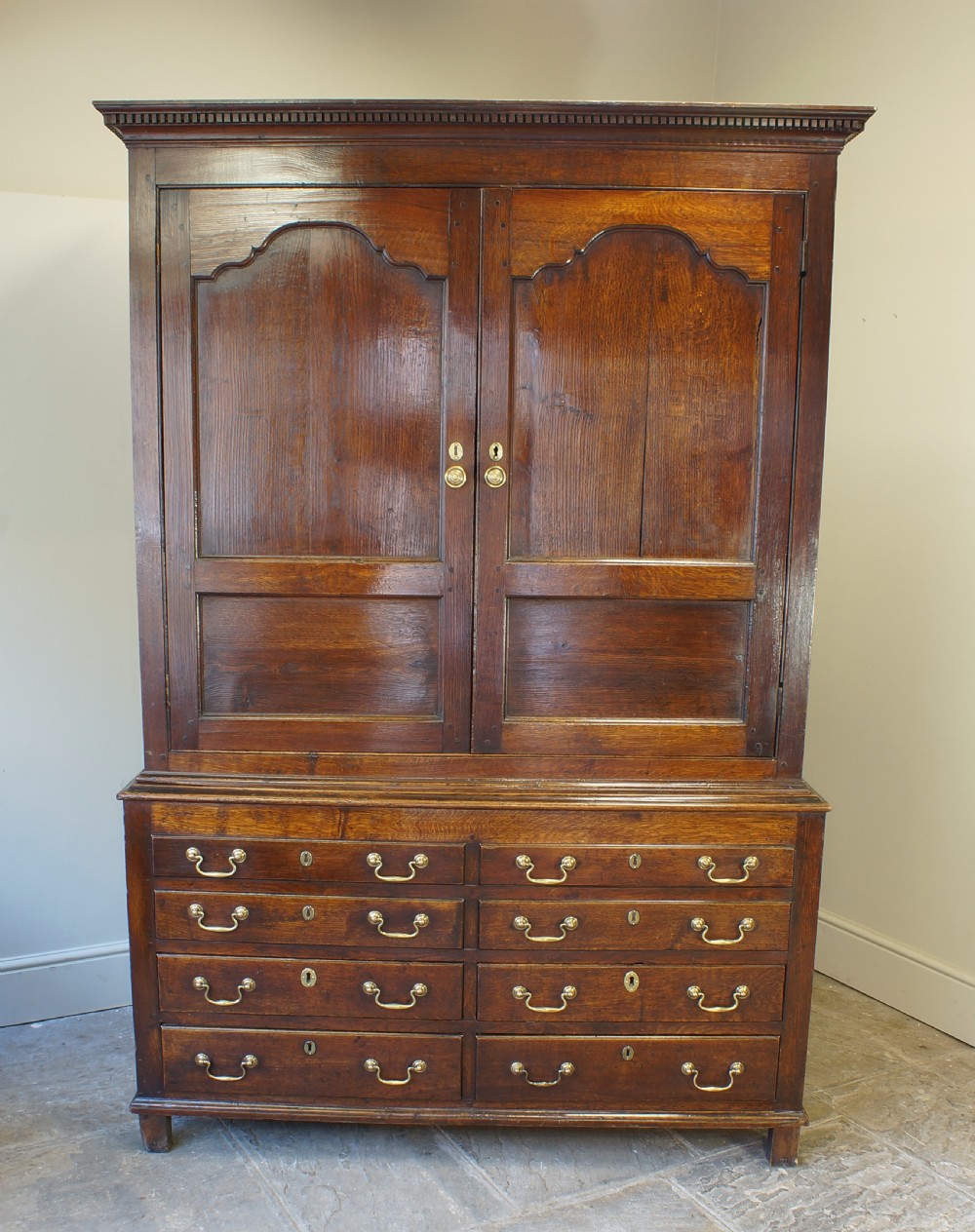 An 18th-century Georgian Welsh oak linen press cupboard featuring two arched panel doors over a base section with four rows of brass-handled drawers. View III