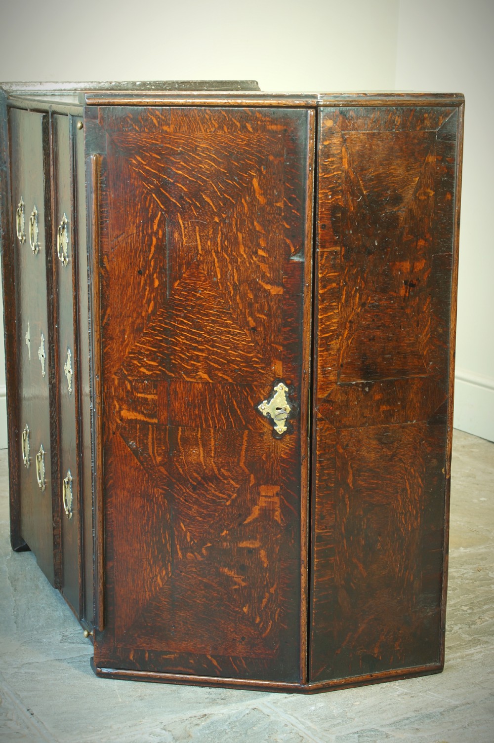 A William and Mary dark oak slant-front bureau featuring geometric parquetry on the lid, three long drawers with brass drop handles, and bun feet. View XII