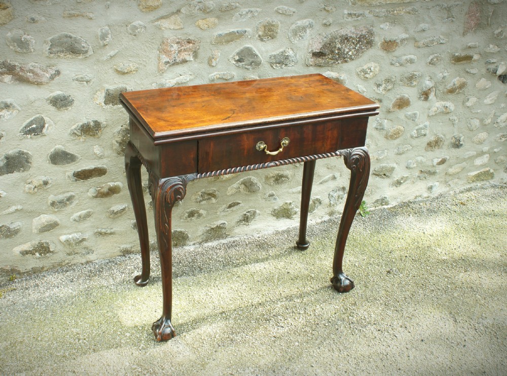 A George II mahogany fold-over card table featuring carved cabriole legs with ball-and-claw feet and a central drawer. View II