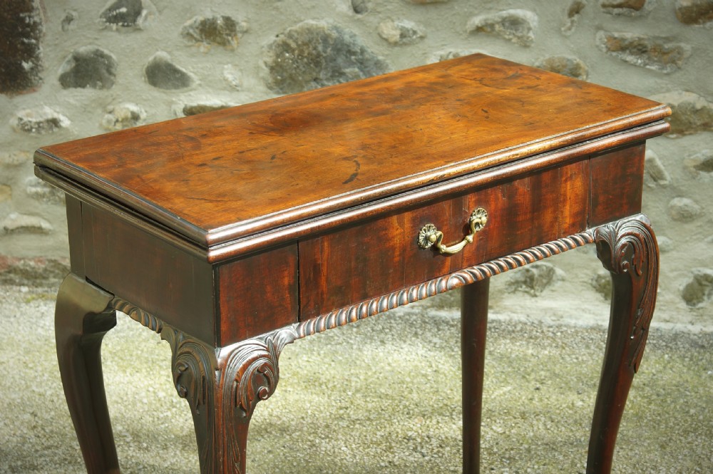 A George II mahogany fold-over card table featuring carved cabriole legs with ball-and-claw feet and a central drawer. View III