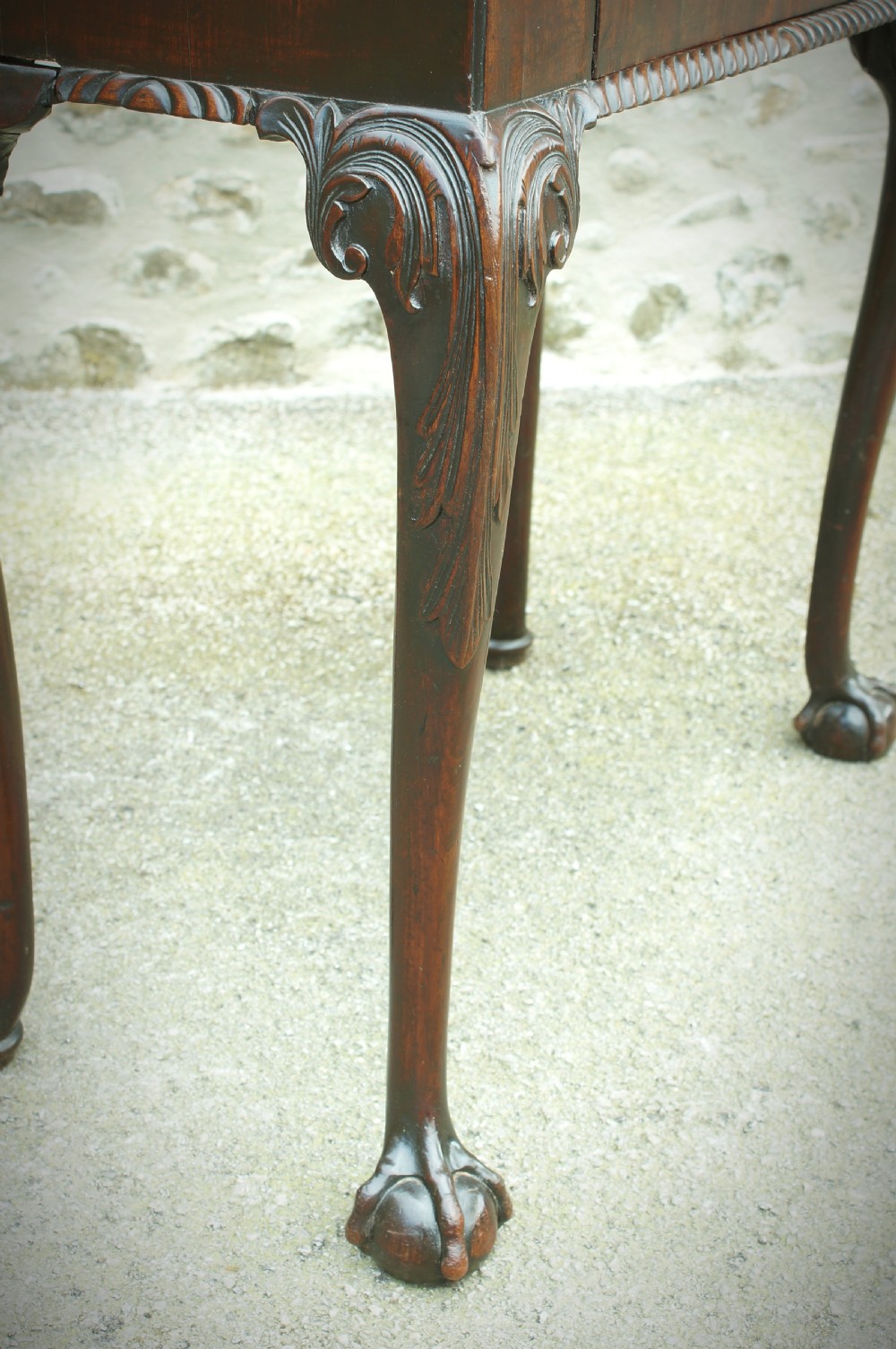 A George II mahogany fold-over card table featuring carved cabriole legs with ball-and-claw feet and a central drawer. View V