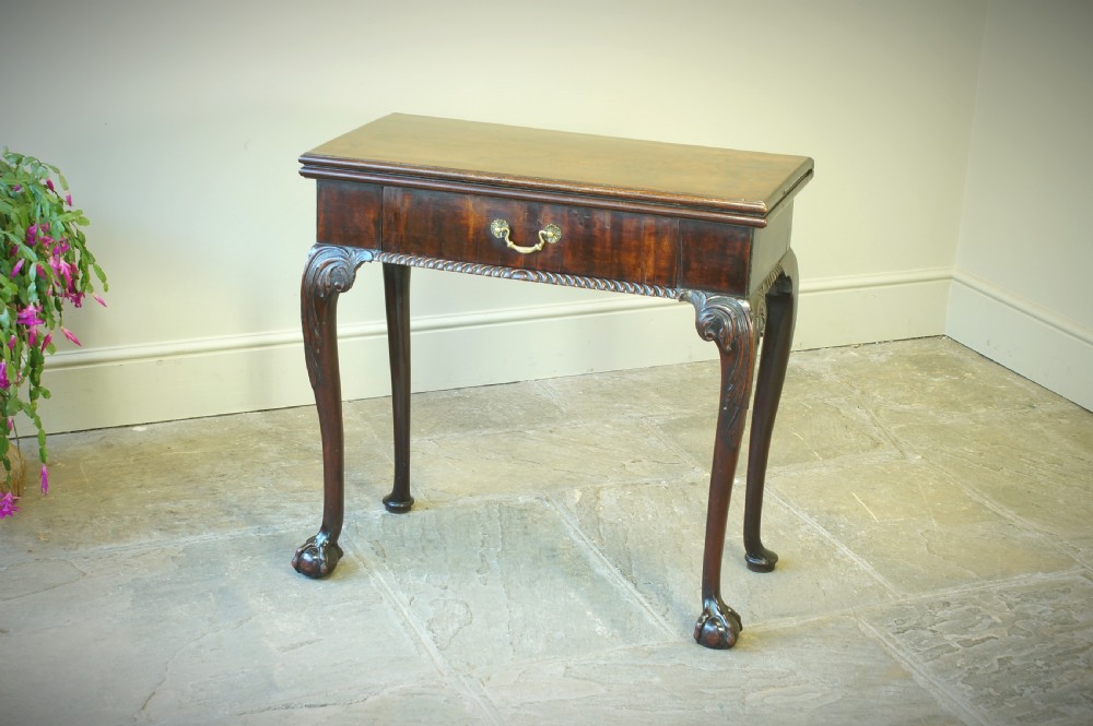 A George II mahogany fold-over card table featuring carved cabriole legs with ball-and-claw feet and a central drawer. View XIII