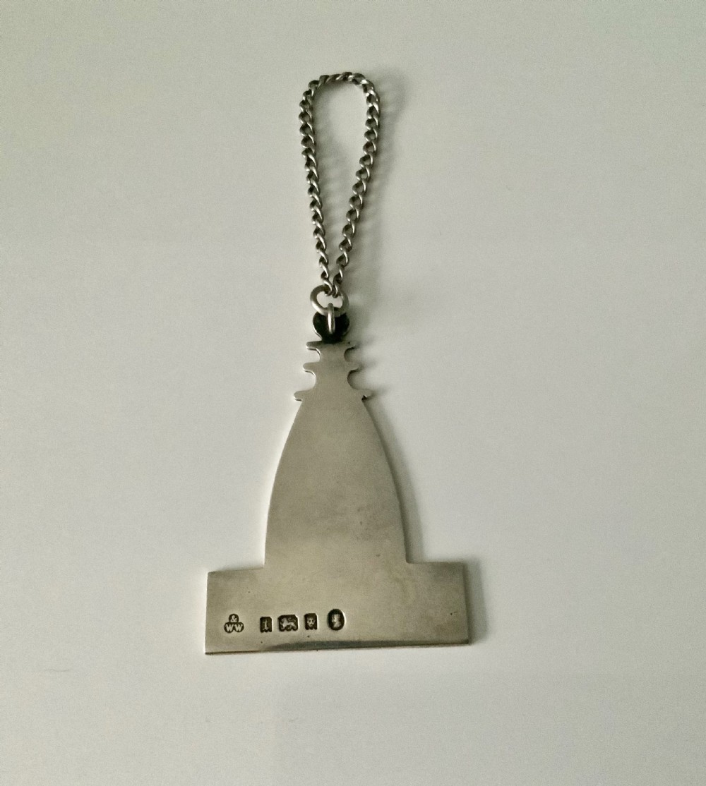 A silver decanter label shaped like an architectural spire above a rectangular plaque engraved with the word SHERRY, attached to a chain. View II