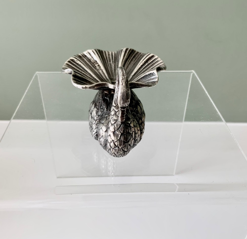 A silver salt cellar fashioned in the shape of a swan with detailed feather texture and a ribbed shell-shaped dish on its back. View II