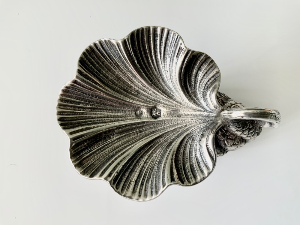 A silver salt cellar fashioned in the shape of a swan with detailed feather texture and a ribbed shell-shaped dish on its back. View V