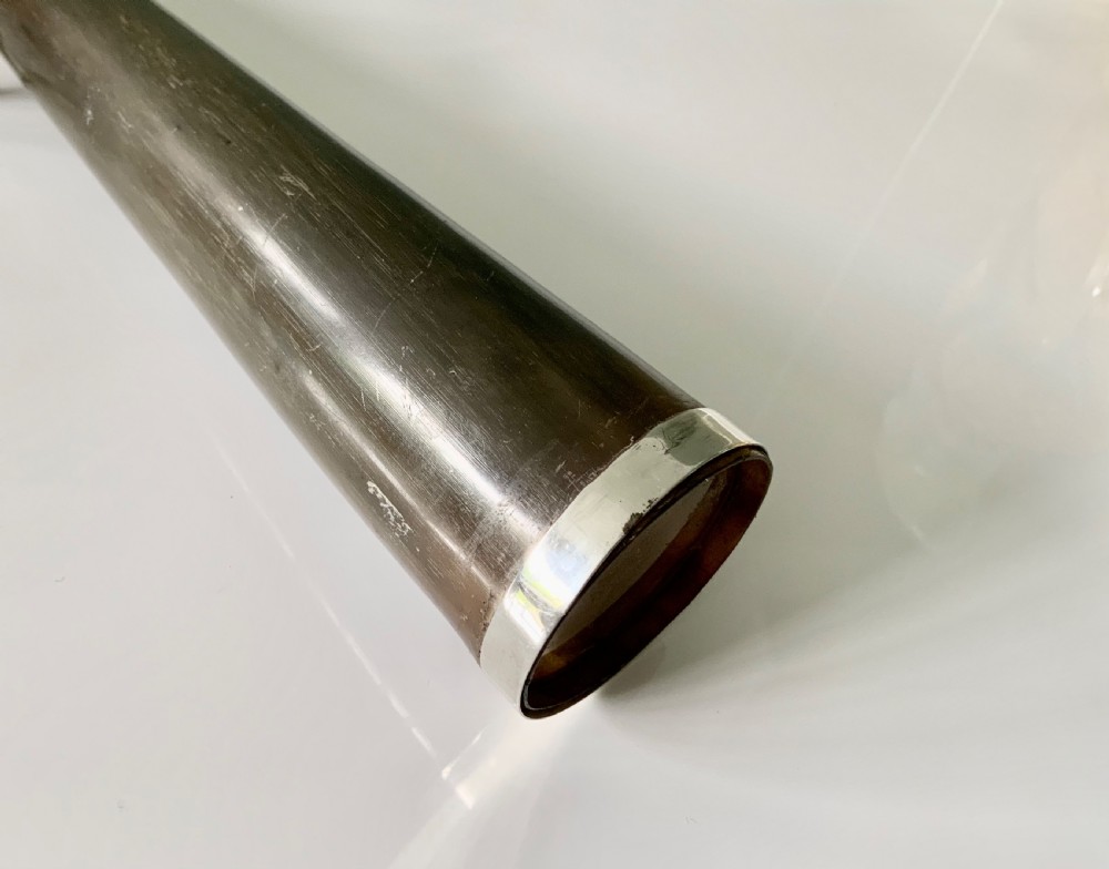 A conical antique spirit flask constructed from dark natural horn with polished silver mounts on the cap and base. View III