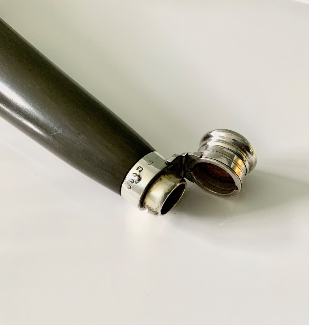 A conical antique spirit flask constructed from dark natural horn with polished silver mounts on the cap and base. View IV