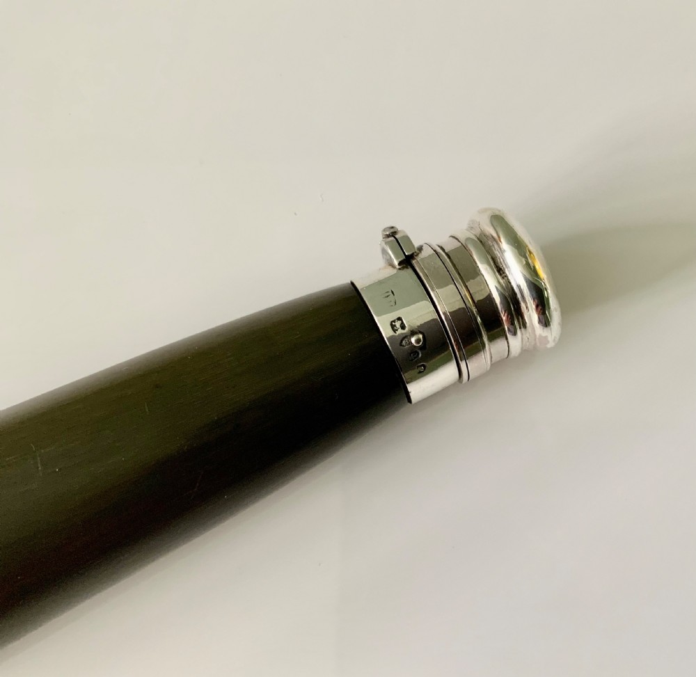 A conical antique spirit flask constructed from dark natural horn with polished silver mounts on the cap and base. View V