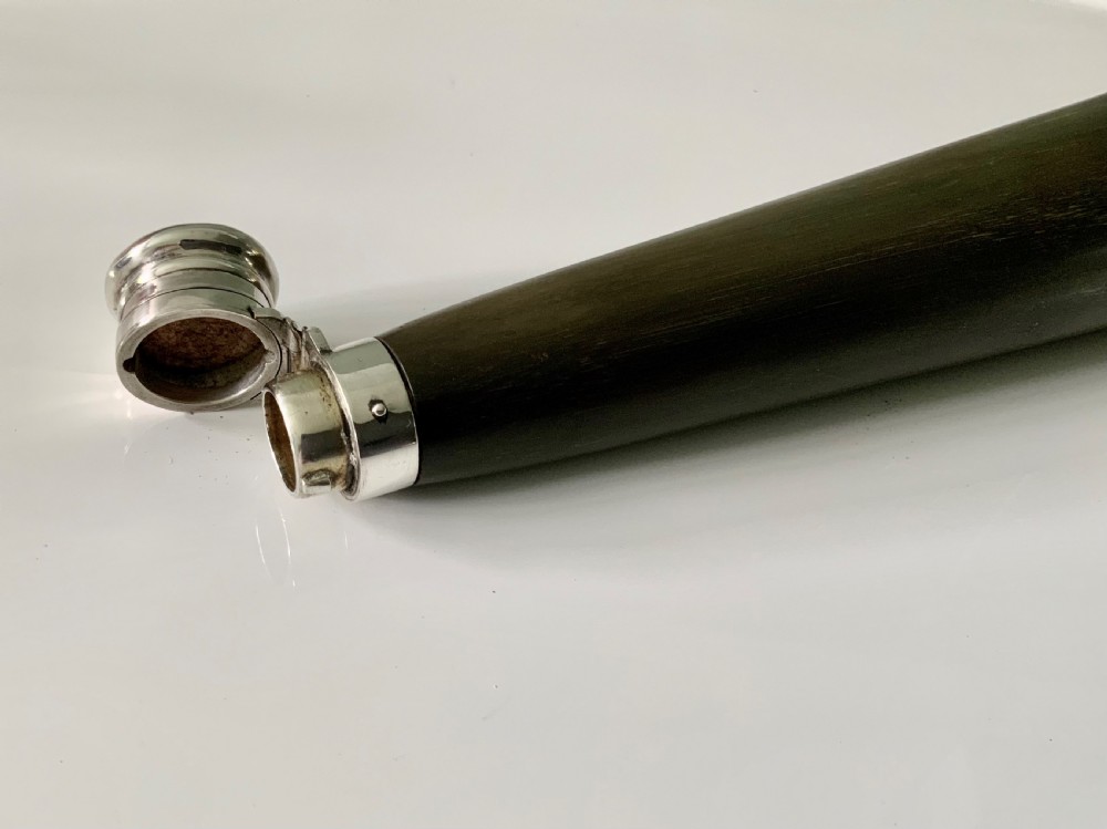 A conical antique spirit flask constructed from dark natural horn with polished silver mounts on the cap and base. View VI
