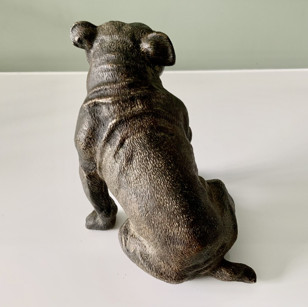A dark cold-painted bronze sculpture of a bulldog seated on its hind legs. View III