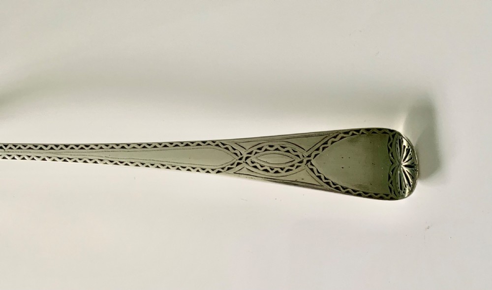A Victorian sterling silver gravy spoon featuring an elongated oval bowl and a tapered handle decorated with geometric borders. View II