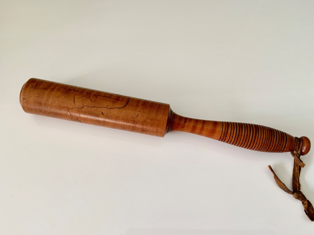 A turned 19th-century satin birch veterinary fleam mallet featuring a cylindrical striking head, a ribbed handle grip, and a tied leather strap. View III