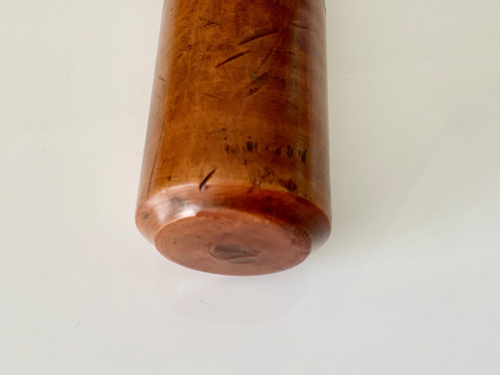 A turned 19th-century satin birch veterinary fleam mallet featuring a cylindrical striking head, a ribbed handle grip, and a tied leather strap. View V
