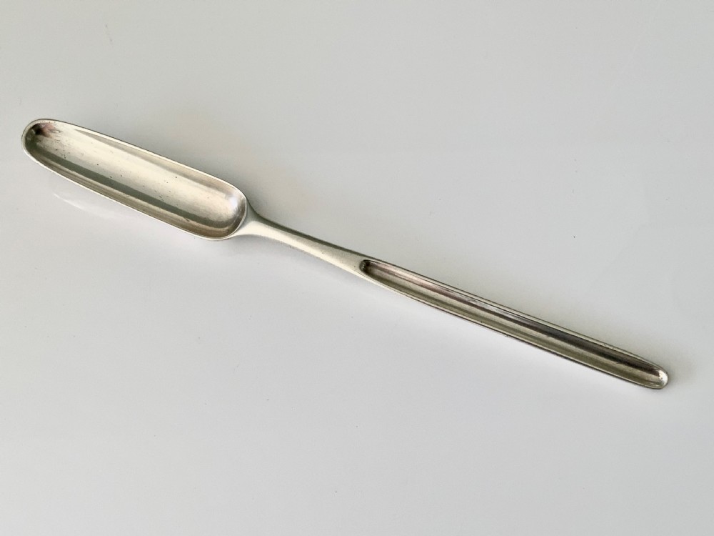 A hallmarked Georgian sterling silver marrow scoop featuring a double-ended channelled design and an engraved crest on the broader scoop. View II