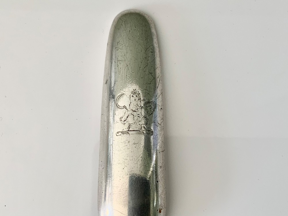 A hallmarked Georgian sterling silver marrow scoop featuring a double-ended channelled design and an engraved crest on the broader scoop. View IV