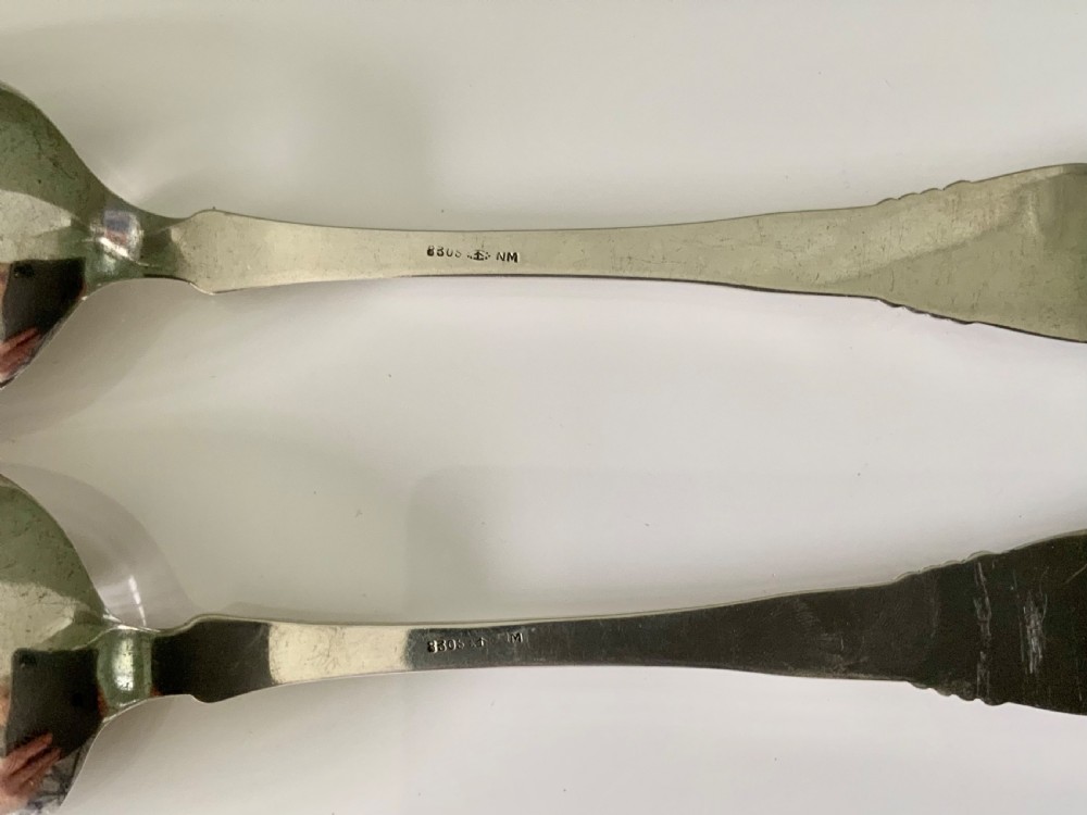 A pair of silver salad servers consisting of a spoon and a three-pronged fork with relief motifs on the handles. View III