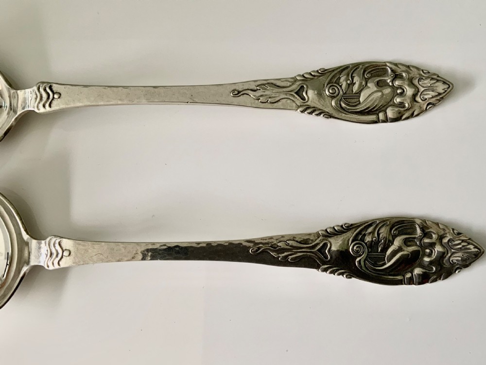 A pair of silver salad servers consisting of a spoon and a three-pronged fork with relief motifs on the handles. View IV