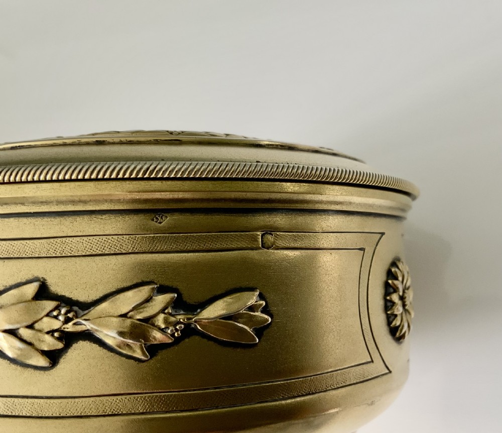 Top view of a round French vermeil silver covered bowl featuring relief carvings of floral rosettes and laurel foliage swags. View V