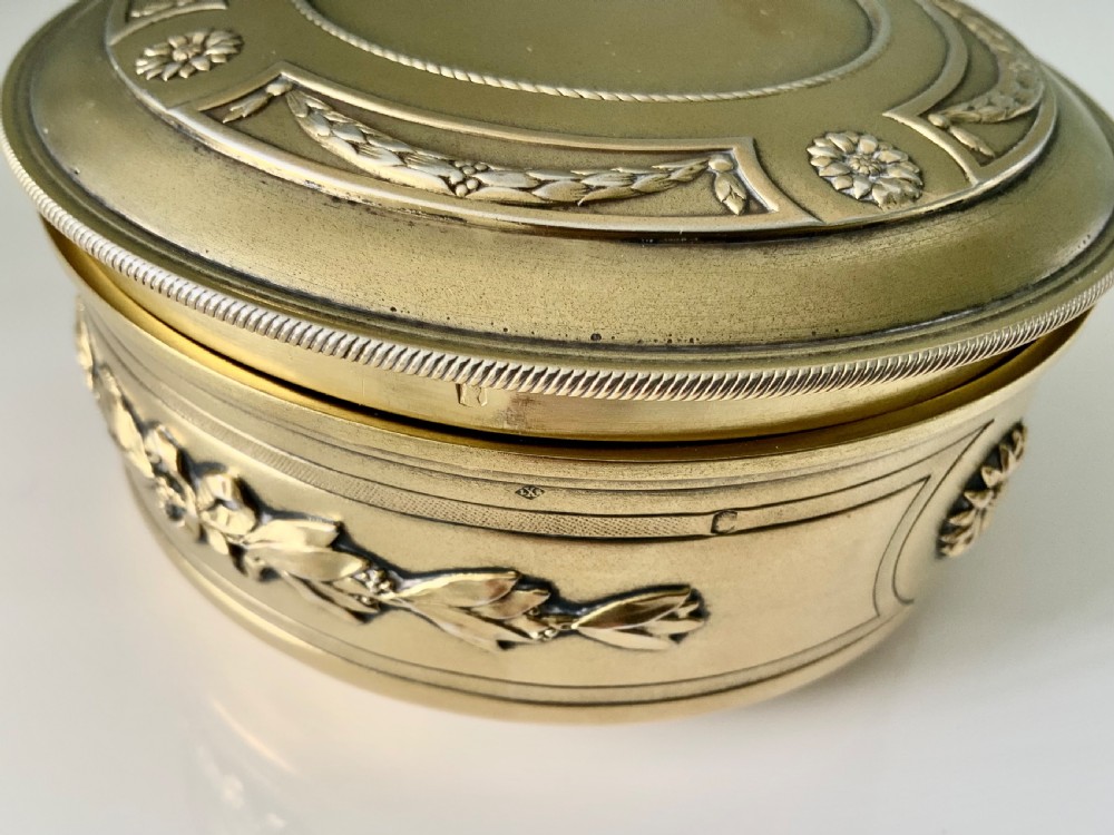 Top view of a round French vermeil silver covered bowl featuring relief carvings of floral rosettes and laurel foliage swags. View VII