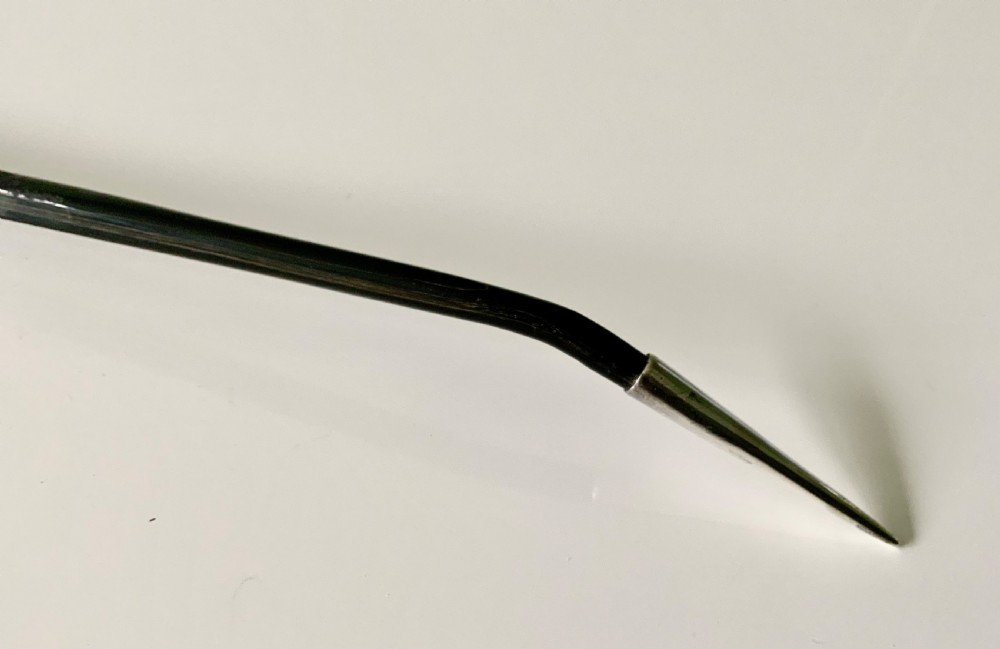 An antique Scottish provincial silver condiment ladle featuring a circular silver bowl, a long twisted black horn stem, and a silver pointed finial. View IV