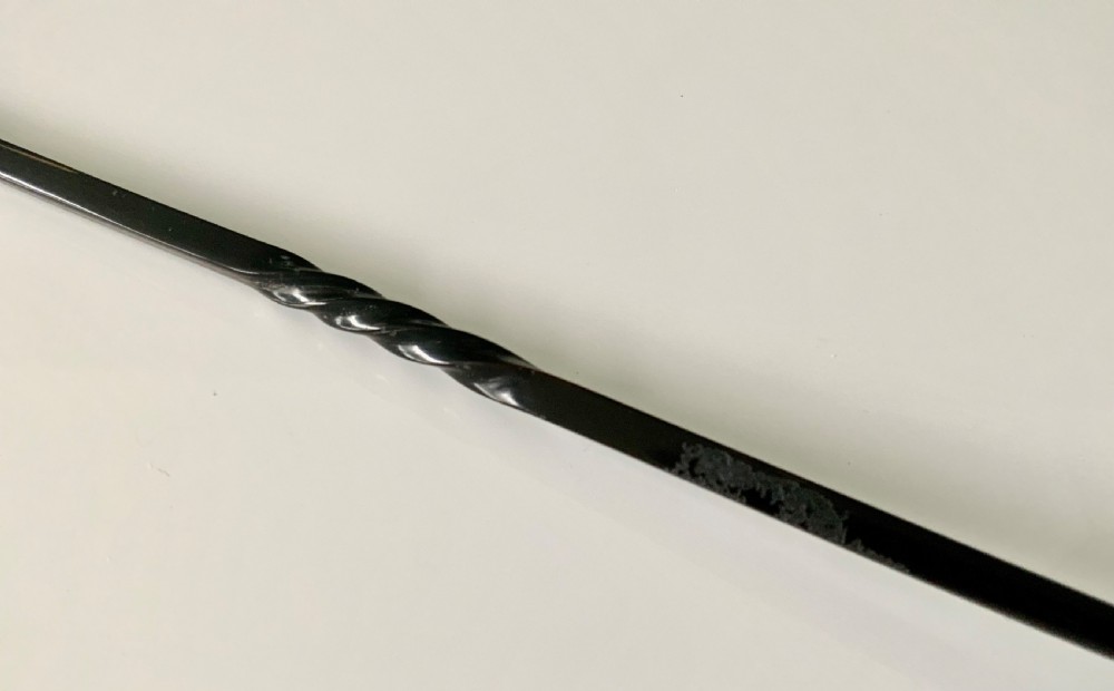 An antique Scottish provincial silver condiment ladle featuring a circular silver bowl, a long twisted black horn stem, and a silver pointed finial. View V