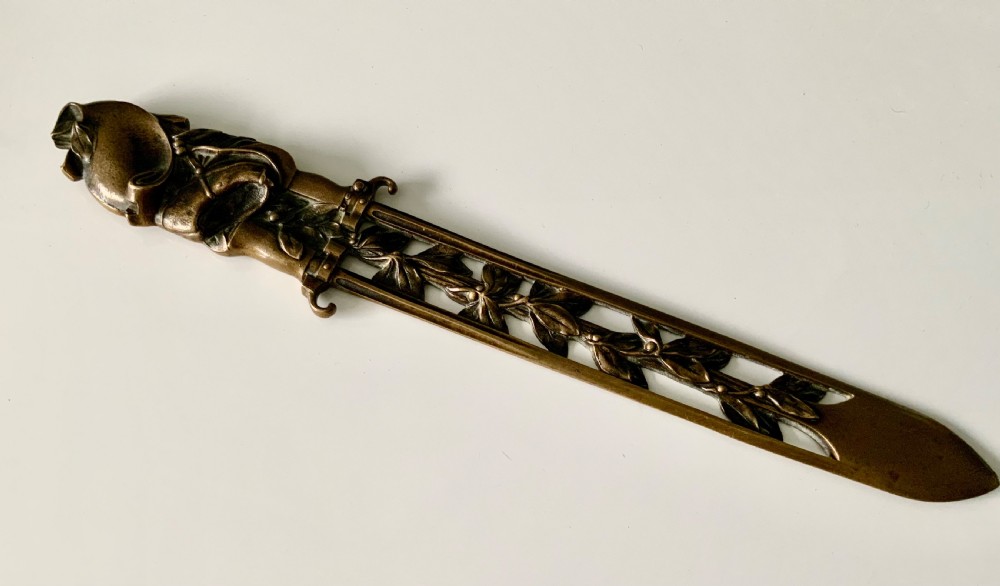 A French gilt bronze letter opener featuring pierced leaf motifs and a sculpted foliage handle.