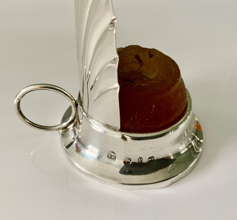 A Victorian silver night light holder featuring a rounded base holding a small wax candle beneath a scalloped shell-shaped reflector shade. View V